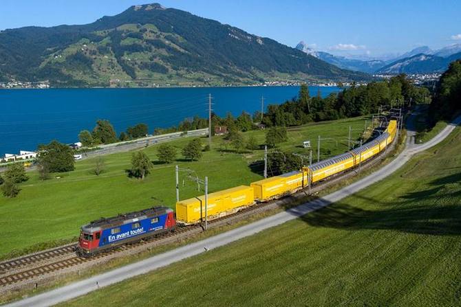 Pociąg Poczty Szwajcarskiej jedzie wzdłuż jeziora