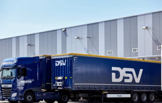 Niebieska ciężarówka DSV stoi pod magazynem